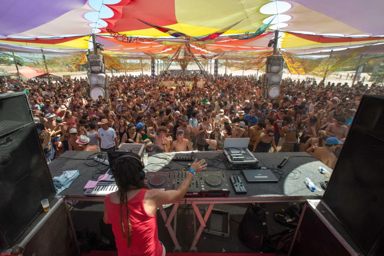 a  stands at a booth surrounded by dj's