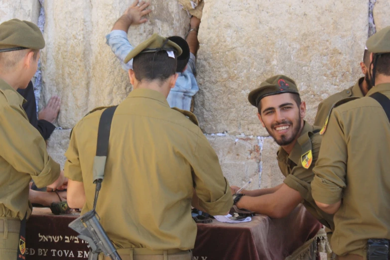 three policemen are smiling by a wall