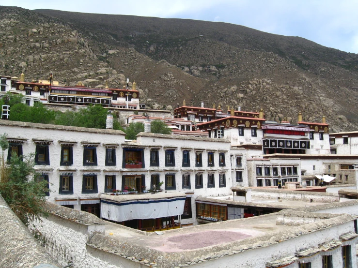 a row of stone buildings against mountains and the sky