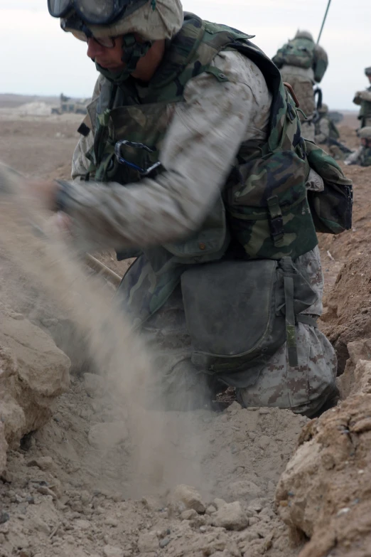 soldier in uniform using sand to throw soing