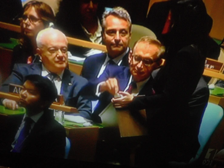 a group of men sitting at a table in a conference