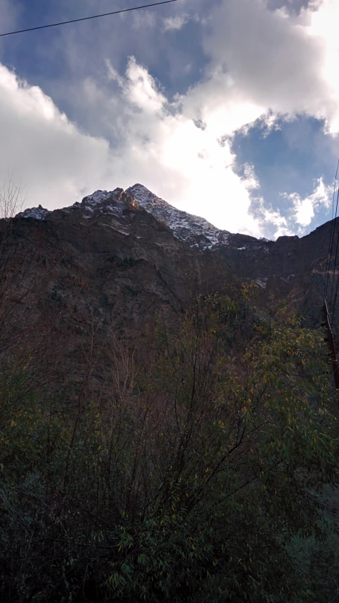 a view of a mountain from behind some trees