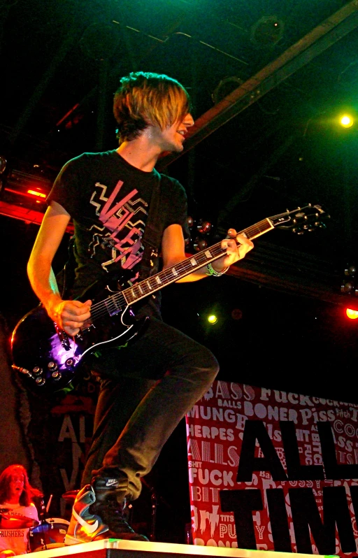 a man with blonde hair plays a guitar