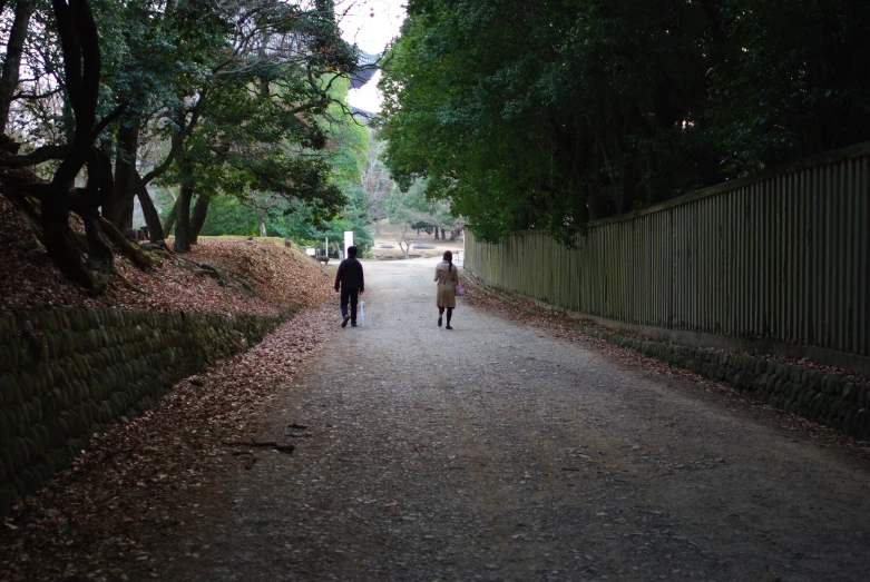 two people walk down the street on a pathway