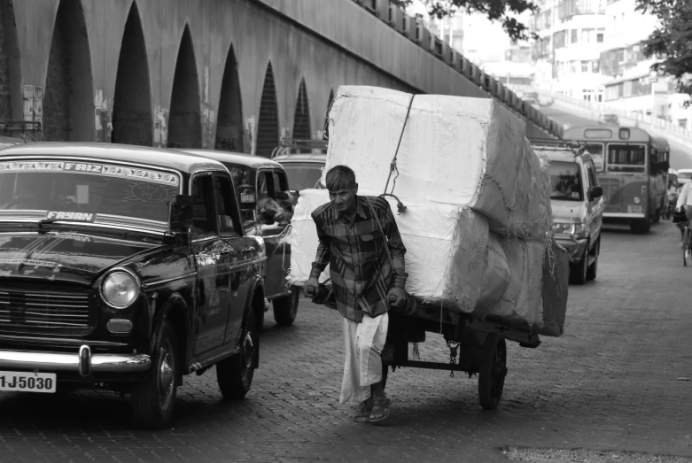 man hing a wagon carrying goods down the street