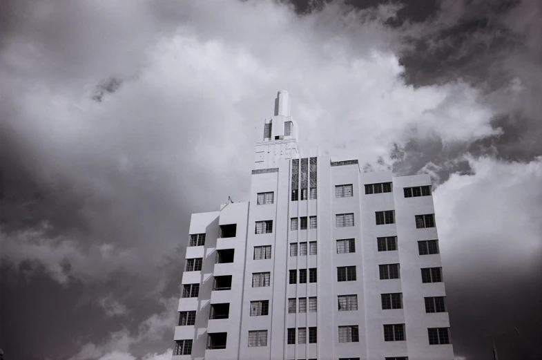 there is an odd looking building with clouds in the background