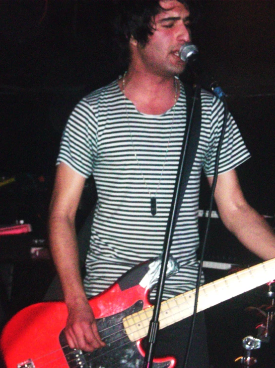 a young man holding a guitar on stage