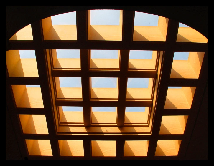 sunlight shining in through a wooden window with bars