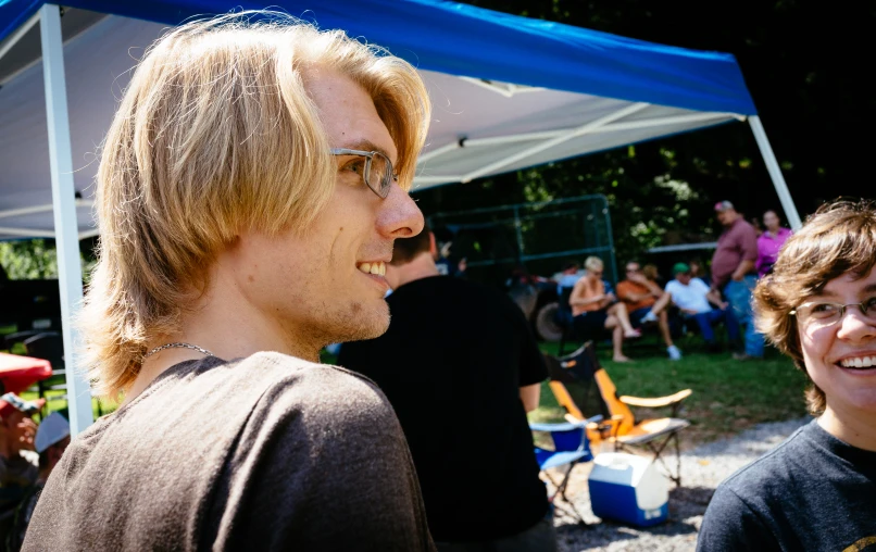 two people sitting under a tent next to each other