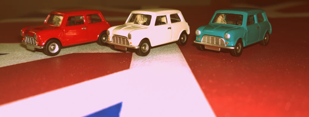 three toys cars on a red, white and blue table