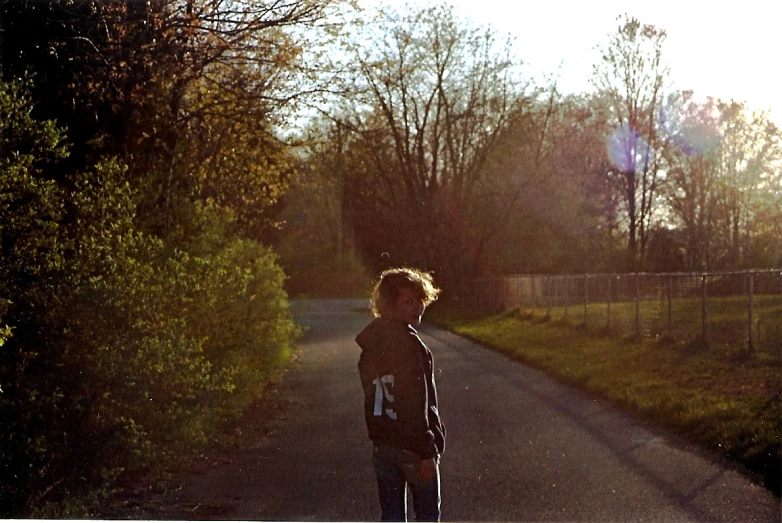 a skateboarder is standing on the side of a road