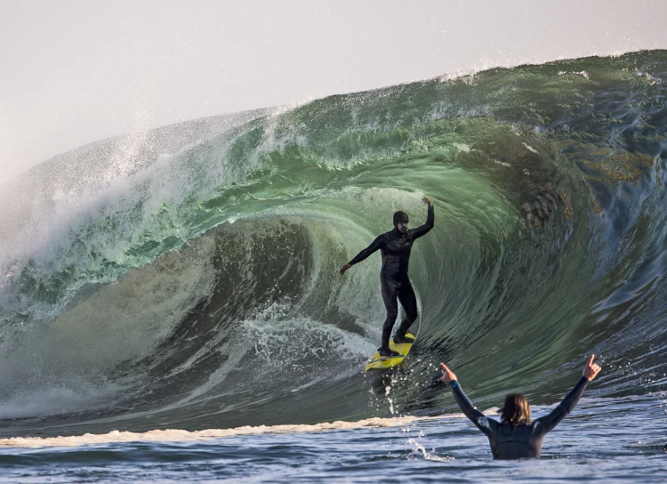 a woman standing on a surfboard riding a wave