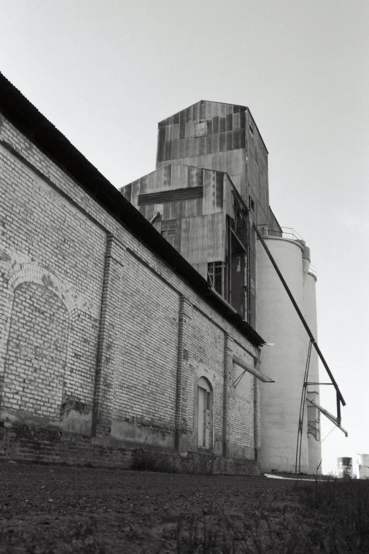 an old brick building stands next to a fence