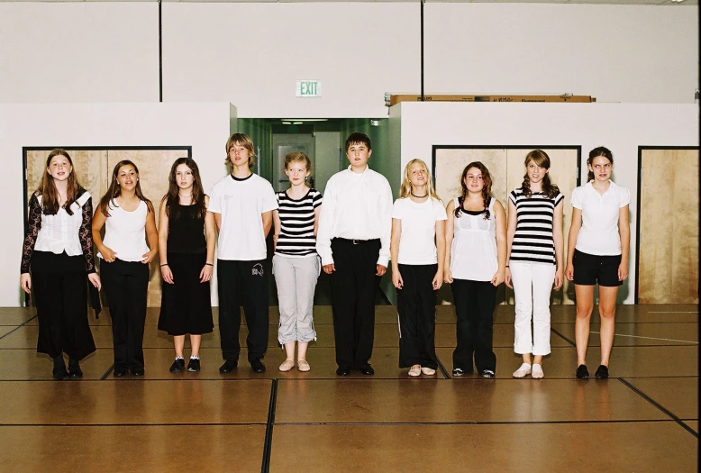 the group of people in white shirts are posing for a picture