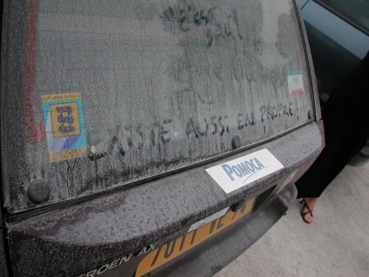 a dirty car with stickers on the hood