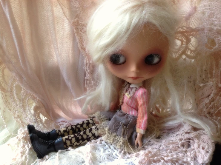 the doll is wearing a pretty dress with her head down