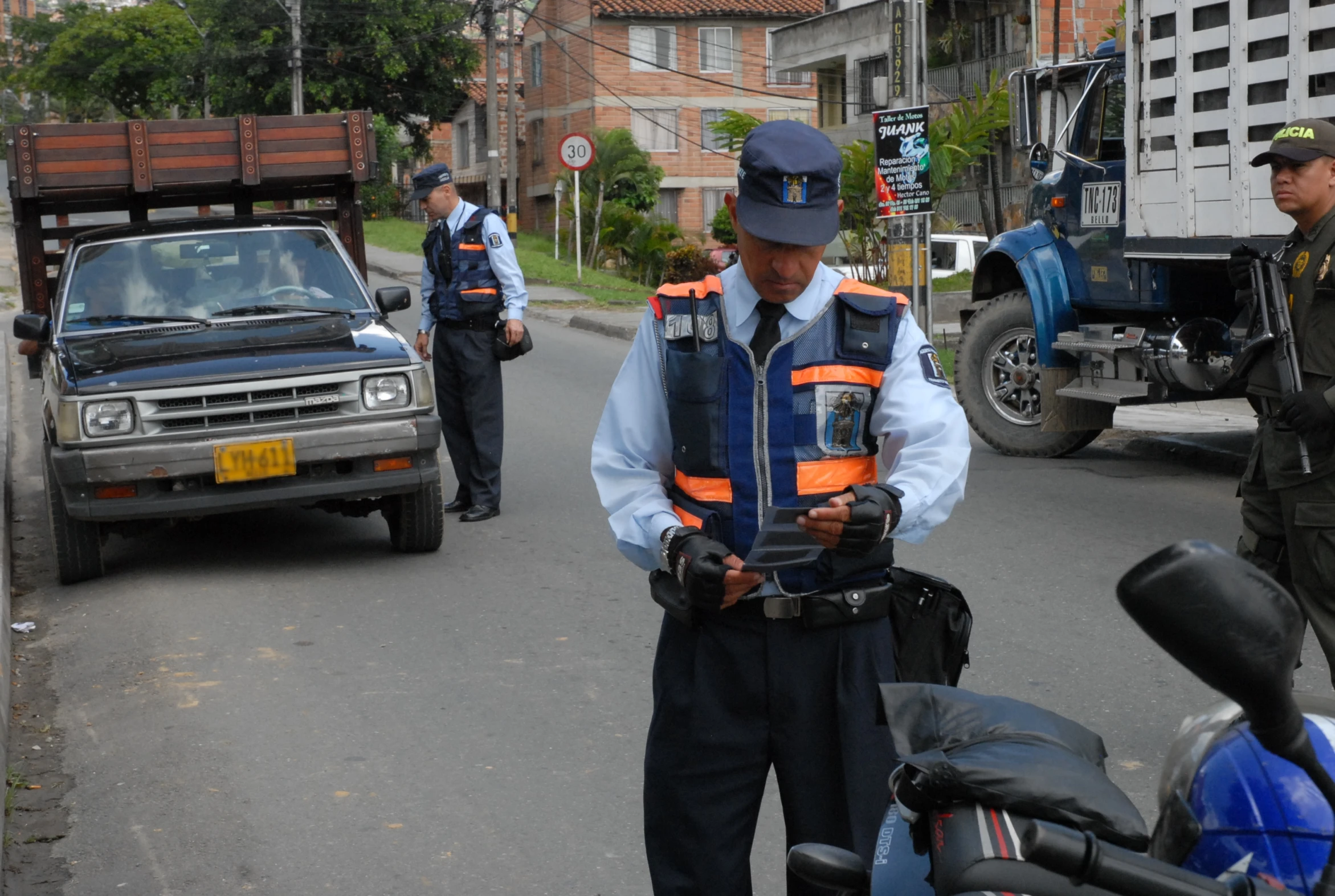 a man in a safety vest standing on the side of a road