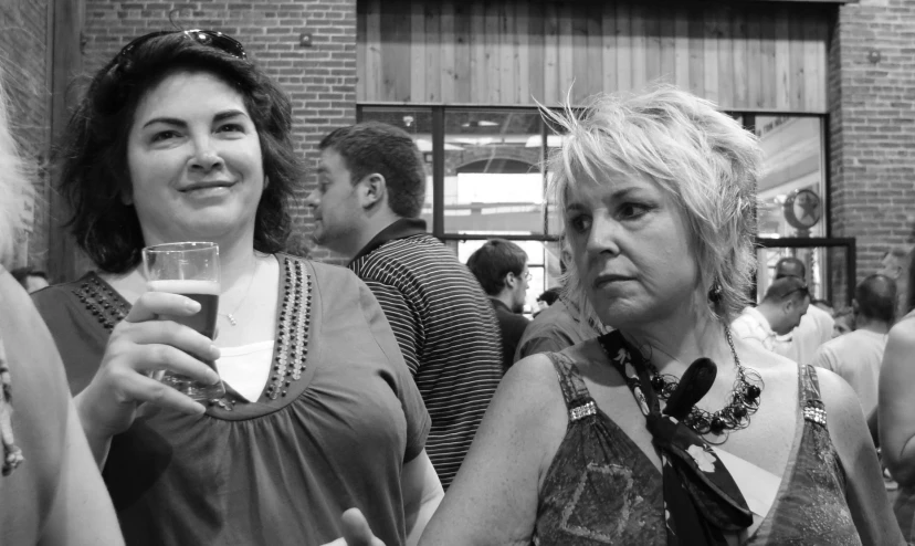 two woman having drinks in a crowded room