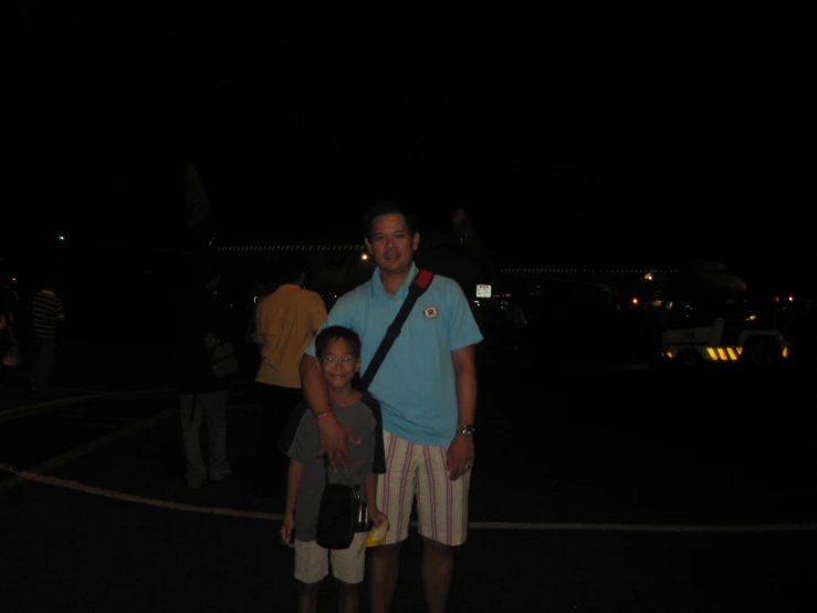 a man and boy in shorts pose in the dark