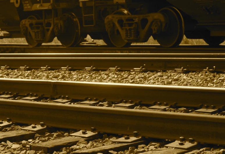 a close up of railroad tracks with a train on the background