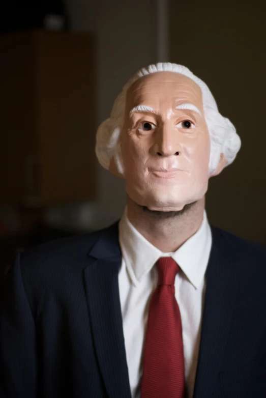 a man in suit and tie with a dummy head