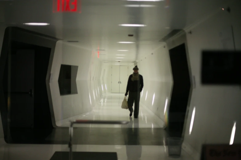 a man with luggage in a long corridor