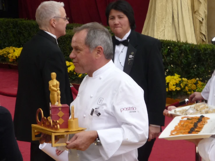 an older man is holding a plate with a pastry on it