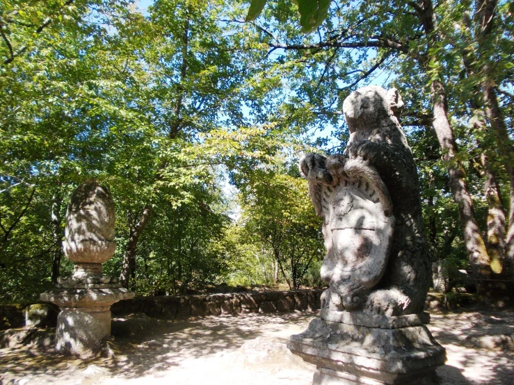 some statues sit near trees in a park