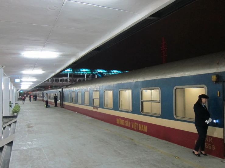 a person standing next to a train while looking at the window