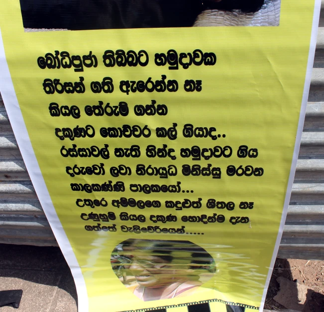 a caution sign hanging outside of a metal fence