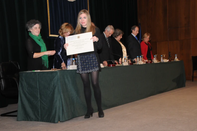 the woman holding a diploma is presenting a presentation