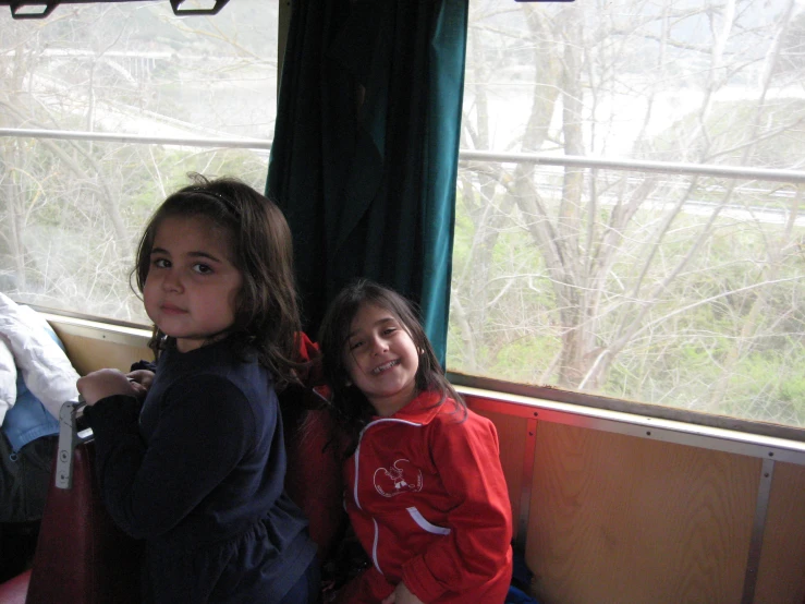 two young children sitting on a train together