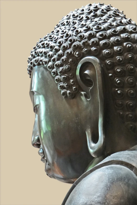 a large metal buddha head with a crown of curls on it's face