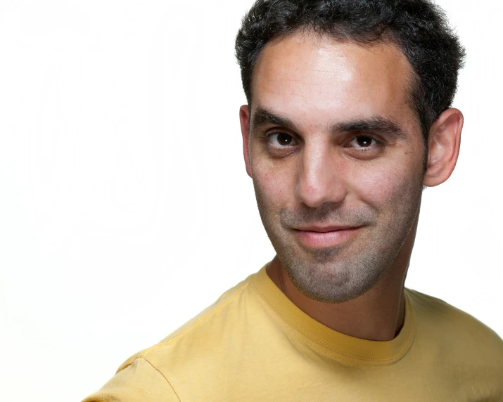 a man in yellow shirt smiling at the camera