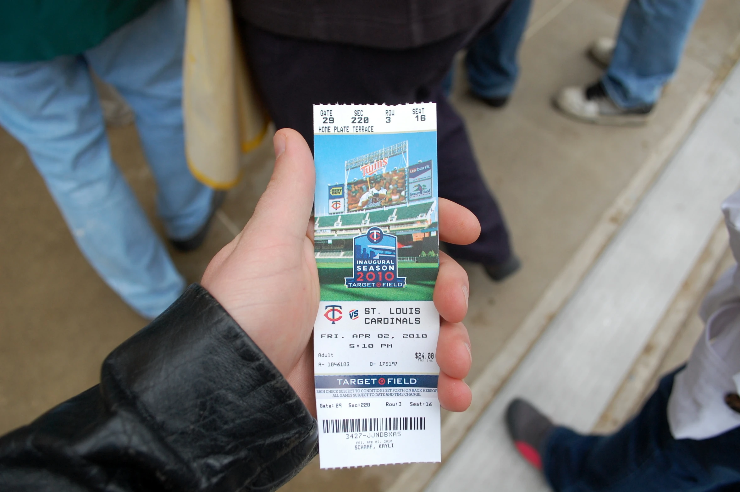 a person holds up a sports ticket to play baseball