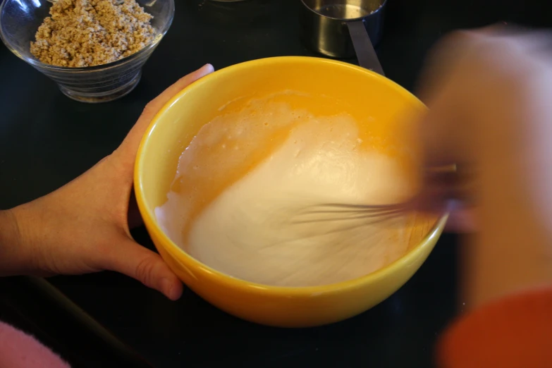 two bowls and a hand with some cereal