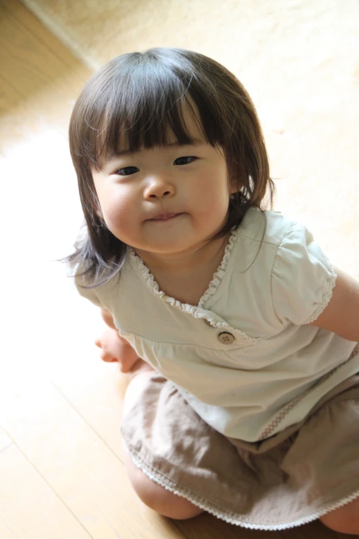 a little girl is sitting down wearing short pants