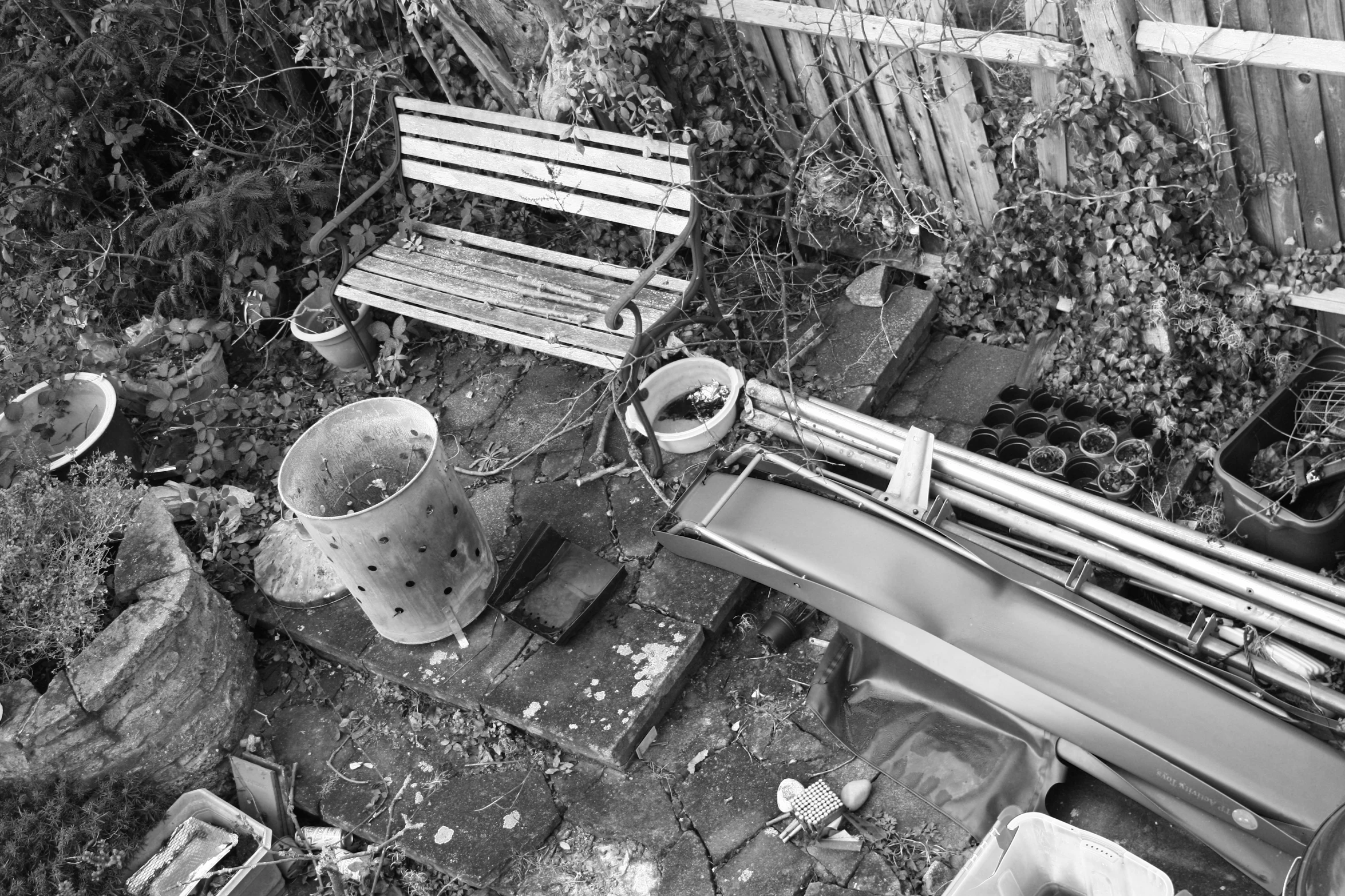 old wooden benches and trash cans in a dilapidated backyard