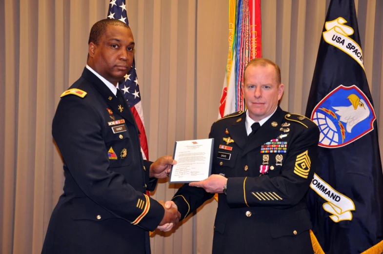 two men in military uniforms, one holding a plaque