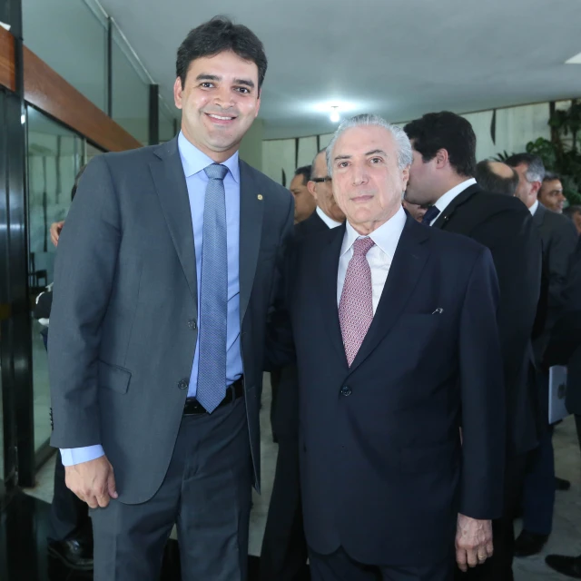 two men dressed in suits and ties standing together