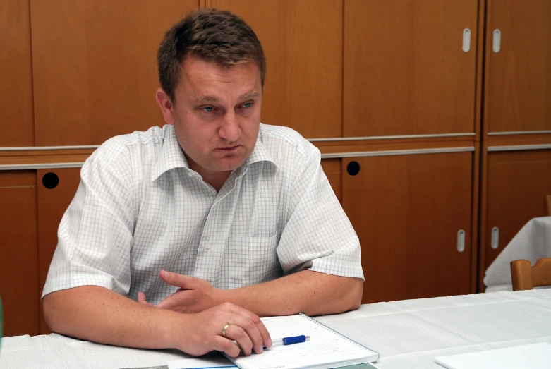 man sitting at a table with notebook in his hands