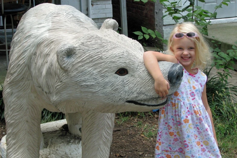 a girl poses for a po next to a plastic bear