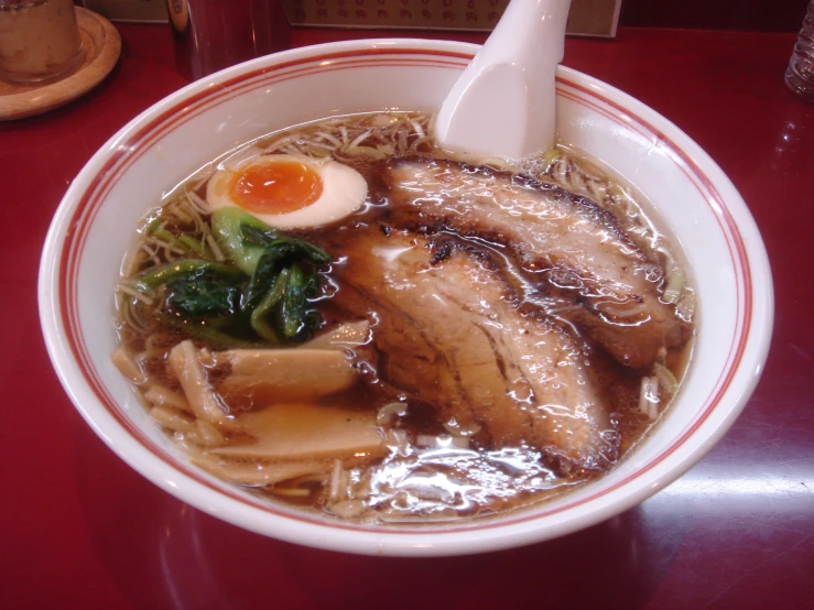 a bowl of ramen with meat and vegetables