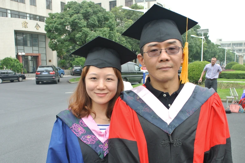 a man and woman dressed in their graduation robes