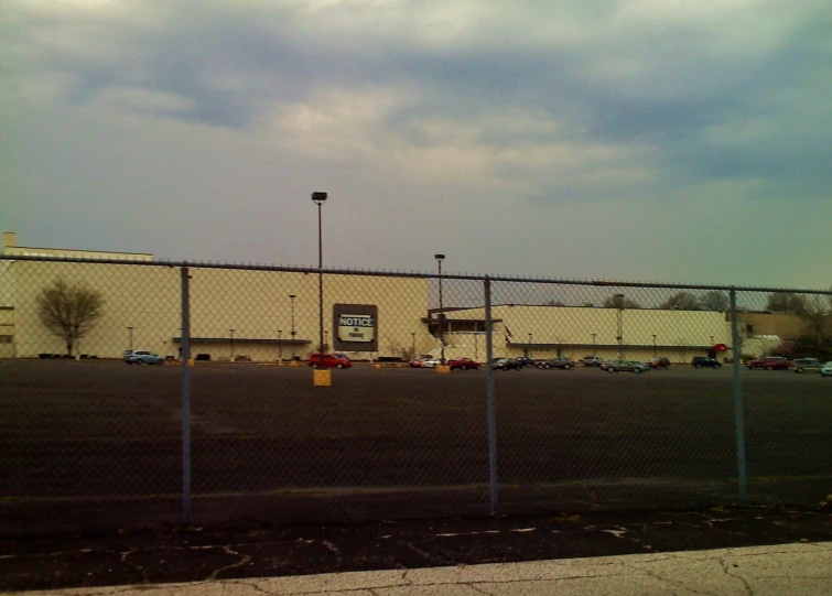 an empty parking lot with a chain link fence next to it