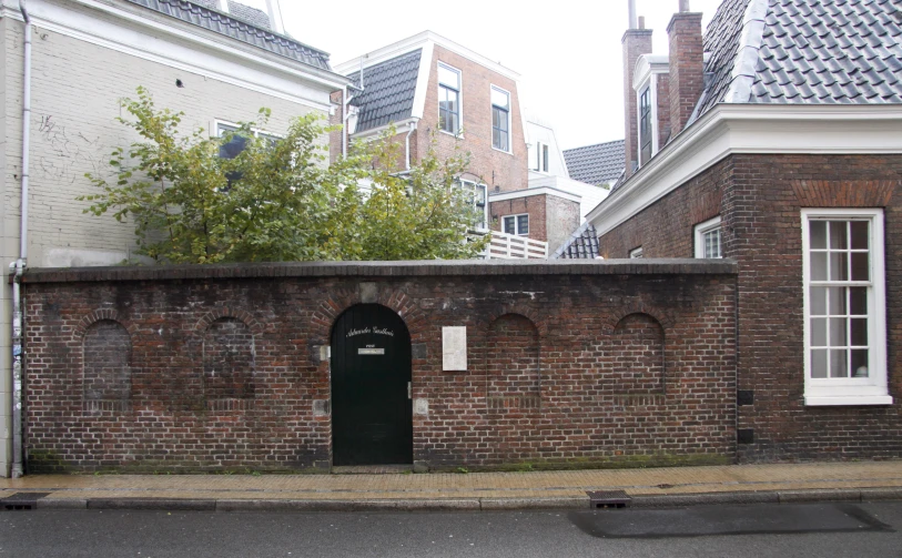 a brick building in an urban area next to a tree