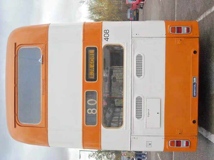 an orange and white bus with some windows