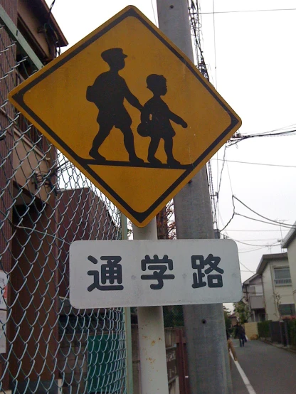 an image of a child crossing sign posted in english and chinese