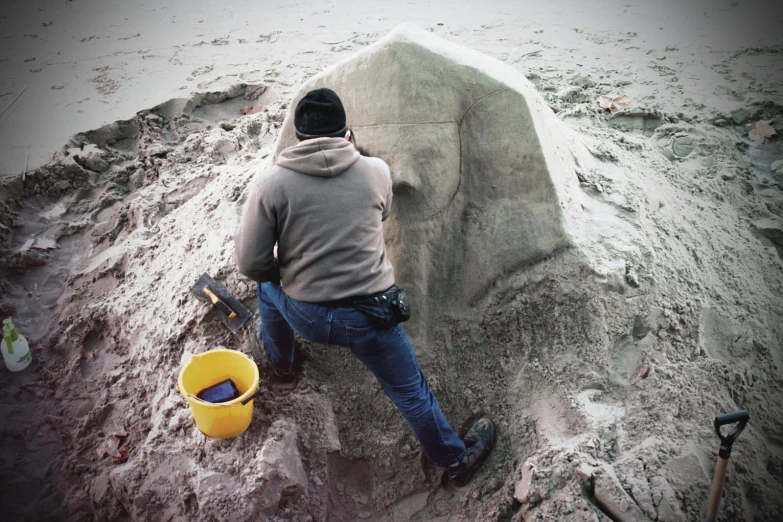 a person sanding next to a sandy bench and shovel