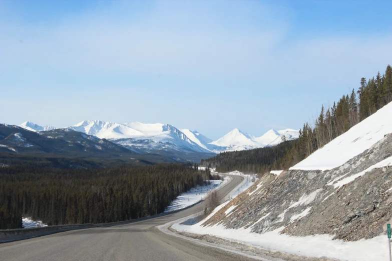 the highway curves around a slope, where two cars are traveling